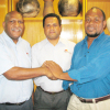 Deal sealed: TFPNG President Joe Yore, Patron Leon Buskens & Finance Director John Melvin deal sealing